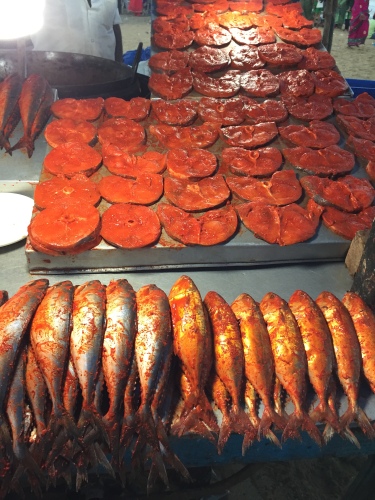 Sea fish marinated with spicy masala, notice the fiery red color. Fish fry stall at Marina Beach, Chennai.